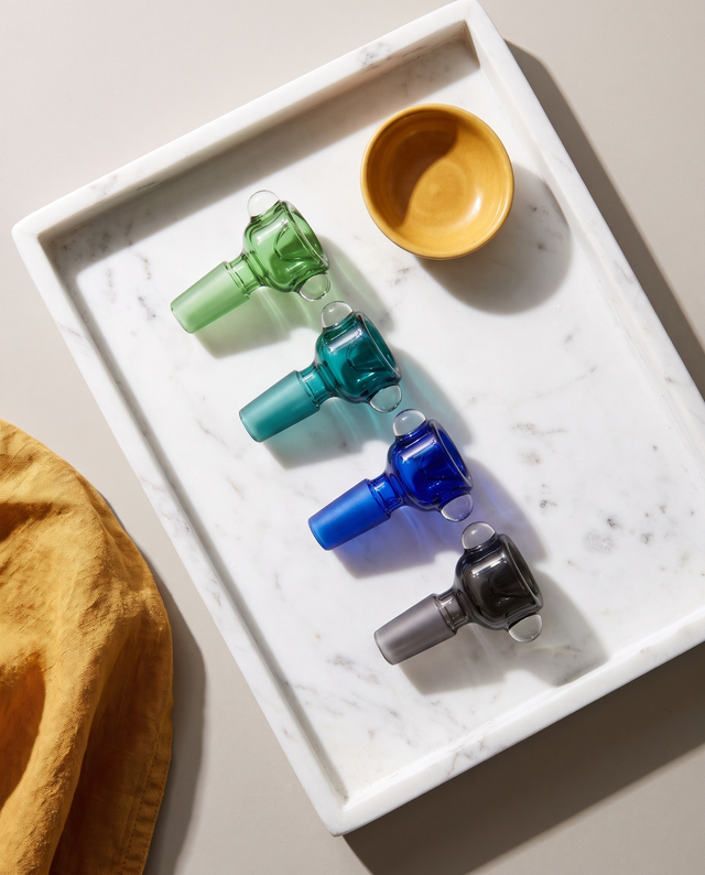 Blue, green, teal and smoke black glass slide bowls on a marble tray
