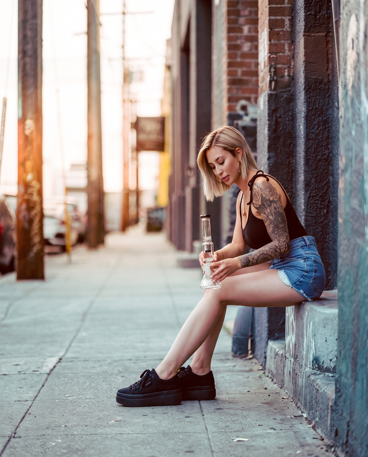 Woman sitting on a city sidewalk holding an Encore Collection glass water pipe